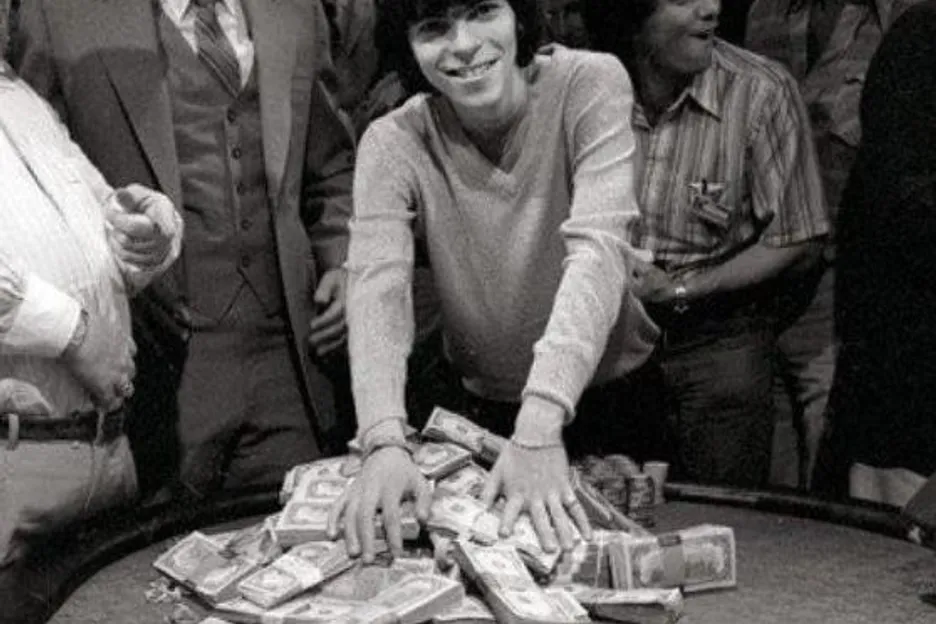 A young Stu Ungar holds a pile of money, having won the WSOP Main Event