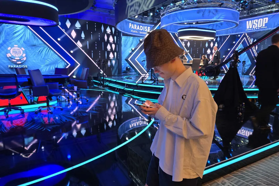 Yinan Zhou checks the PokerOrg updates before his phone is taken away for the stream. 