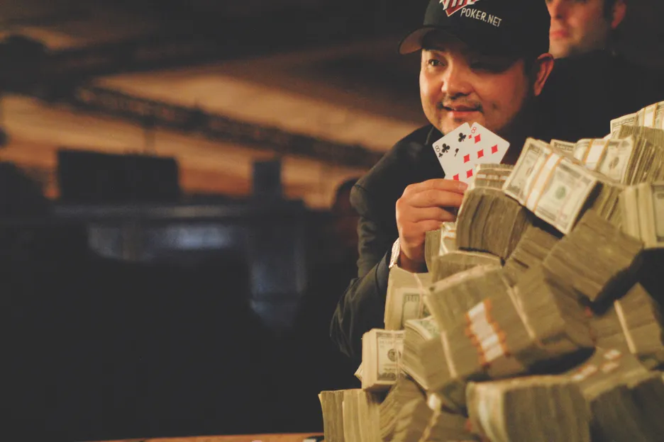 Jerry Yang poses with a pile of cash, having won the WSOP