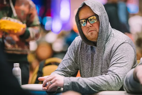 Poker player Matt Hunt wears mirrored glasses and a hoodie at the poker table